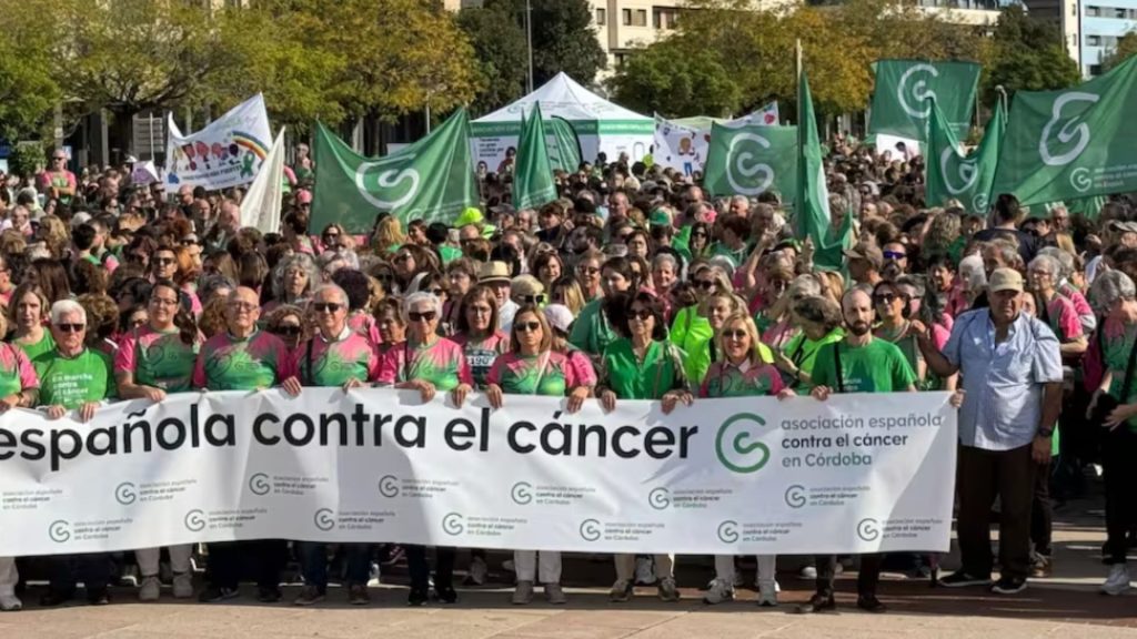 Personas con una pancarta de la asociación española contra el cáncer en Córdoba