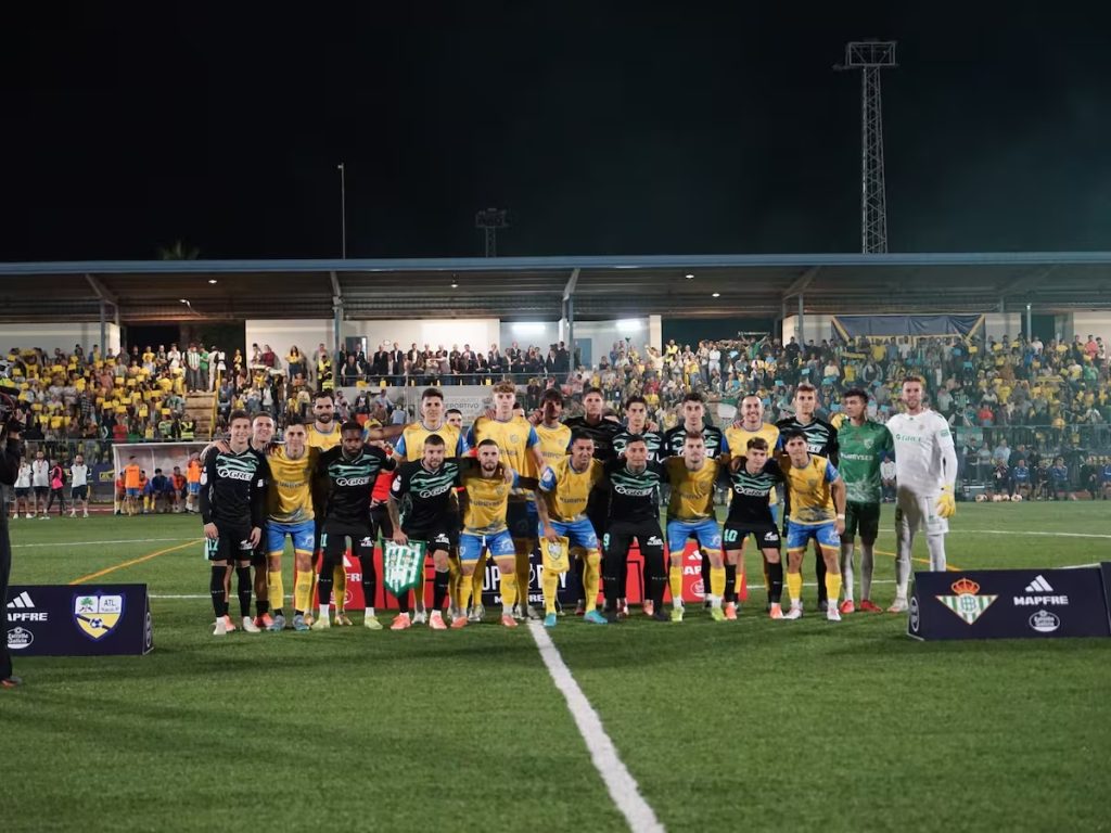 Los jugadores del Atlético Palma del Río y Real Betis posan juntos antes del inicio de su partido de Copa del Rey.