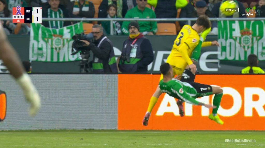 Antony procede a ejecutar una chilena para pasar el balón a un compañero, impactando en la cara de Joel Roca que llega justo antes a despajar el esférico.