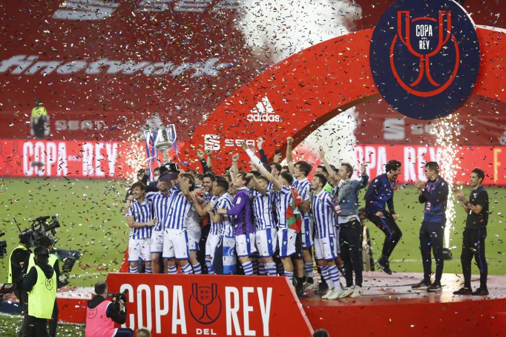 Los jugadores de la Real Sociedad levantan el trofeo de Copa del Rey obtenido en 2021 y correspondiente a la edición de 2020 aplazada por el Covid. Esta fue la primera final de Copa acogida por La Cartuja tras su acuerdo de asociación con la RFEF.