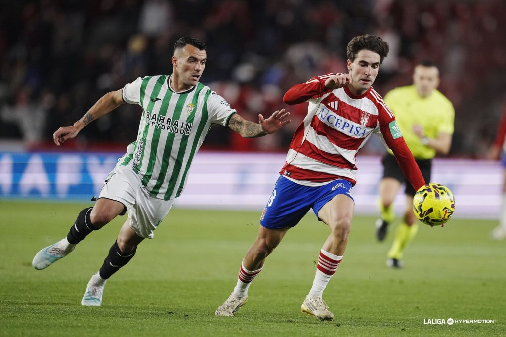 Álex Martín mira como Pedro Alemañ se escapa de su marca con el balón en el derbi andaluz entre Granada y Córdoba en el Nuevo Los Cármenes.
