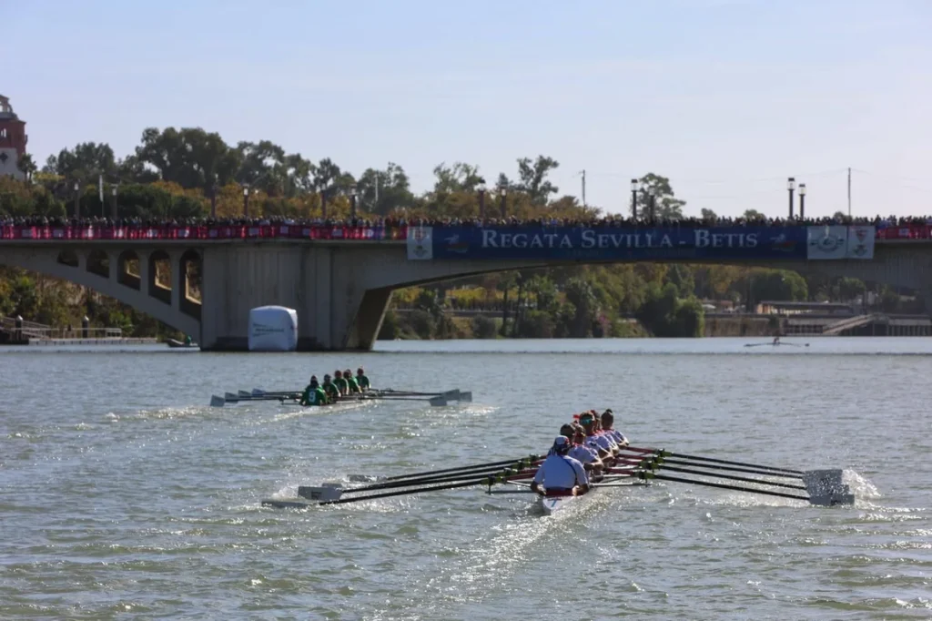 Regata Sevilla -Betis en categoría femenina con la barca verdiblanca por delante de la sevillista en la carrera.