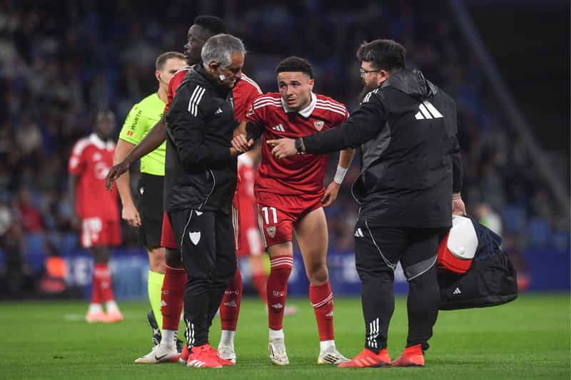 Rubén Vargas, visiblemente dolido, es ayudado por miembros del cuerpo médico del Sevilla para salir del campo. Una más de la plaga de lesiones antes del derbi.