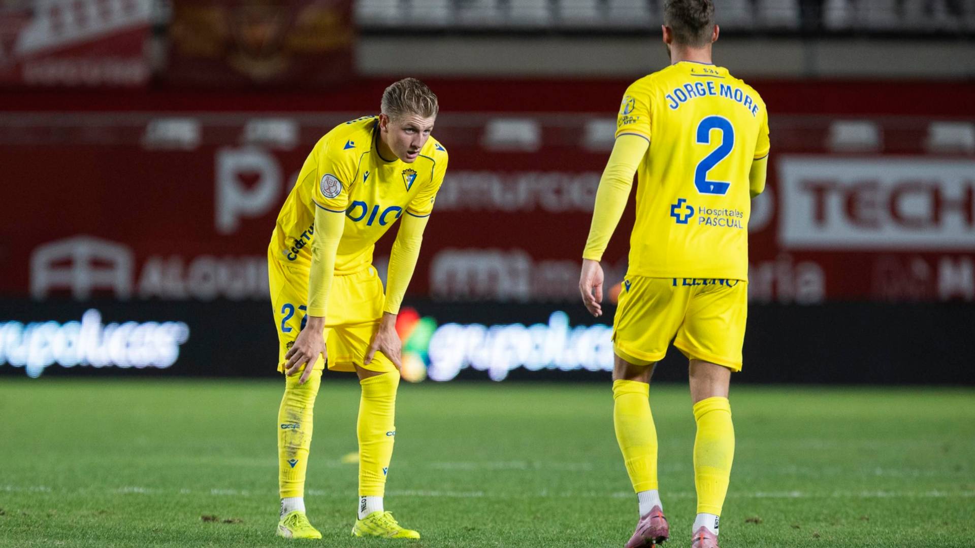 Dos jugadores del Cádiz se lamentan en el césped del Enrique Roca de Murcia tras la eliminación de su equipo en Copa del Rey.