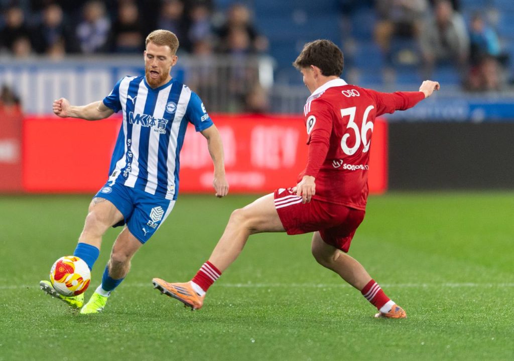 Carlos Vicente pasa el balón a un compañero para superar la marca de Oso durante el partido de Copa del Rey entre Alavés y Sevilla.