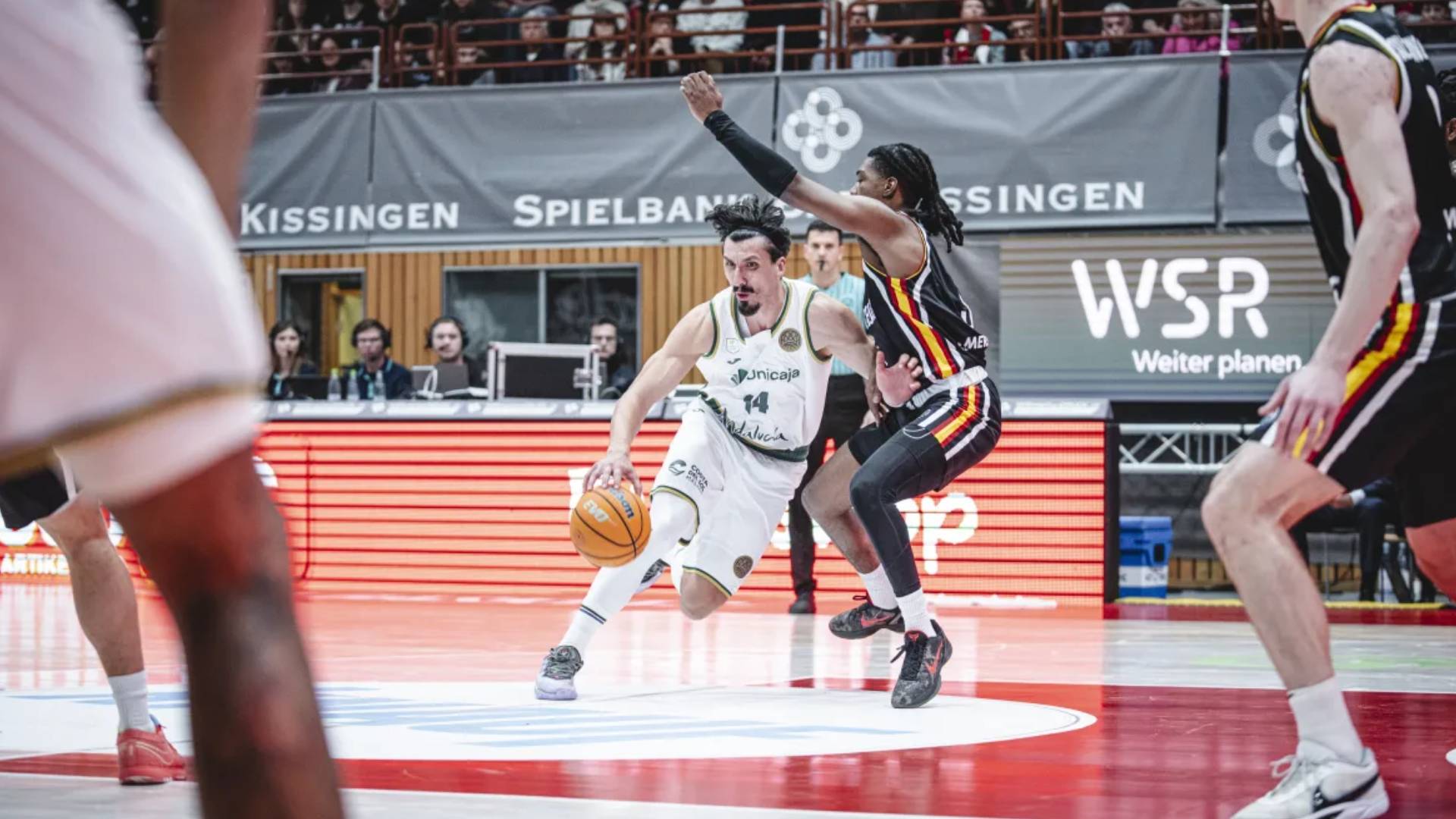 Nihad Djedovic (Unicaja) realiza una entrada a canasta mientras es defendido por Marcus Carr (Würzburg) durante el cuarto partido de la fase de octavos de la Basketball Champions League